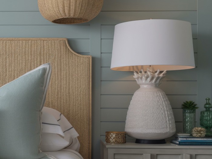 Bed and nightstand with textured headboard and lamp.